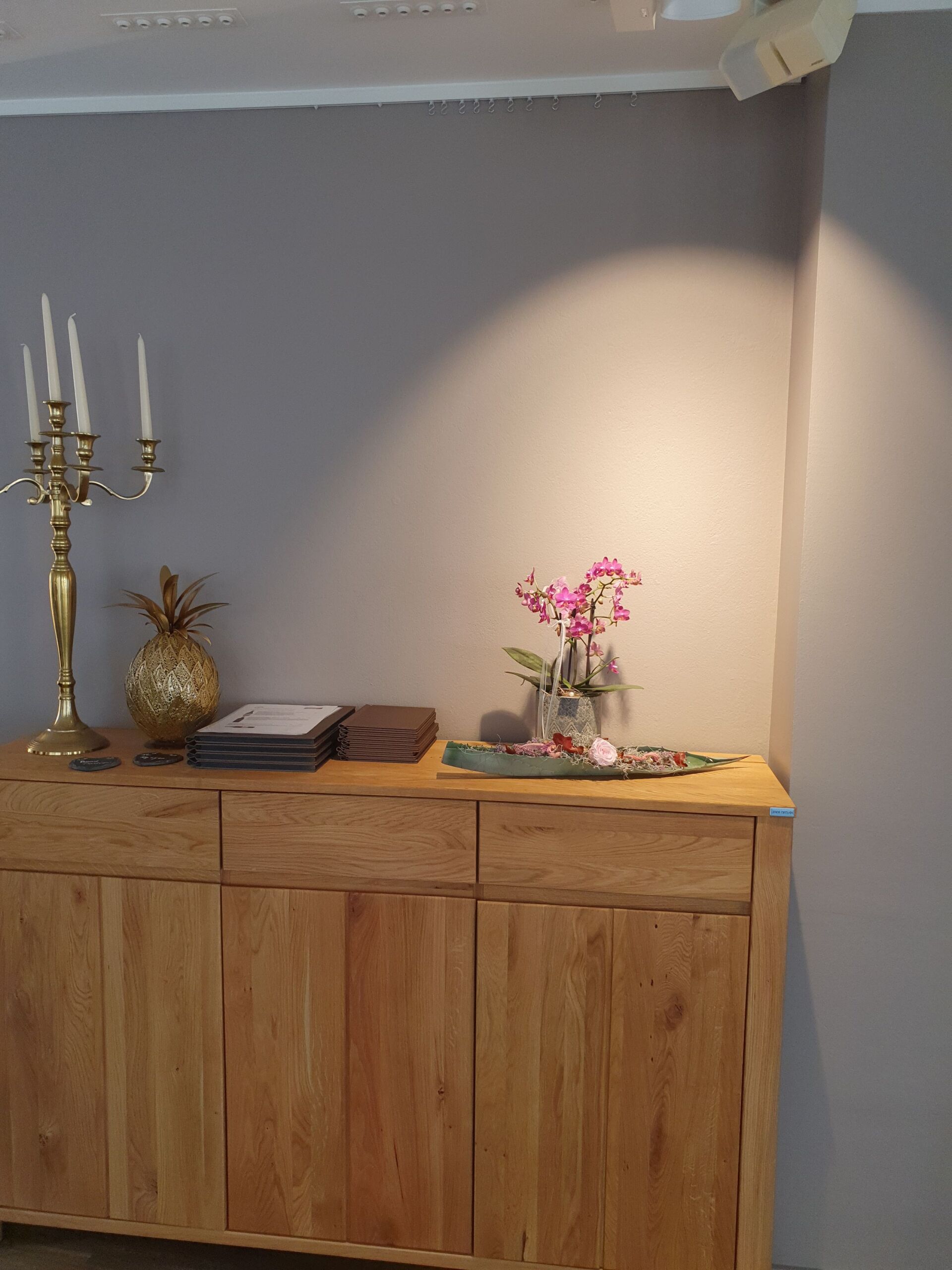 Ein Holzschrank mit einer Vase mit Blumen darauf