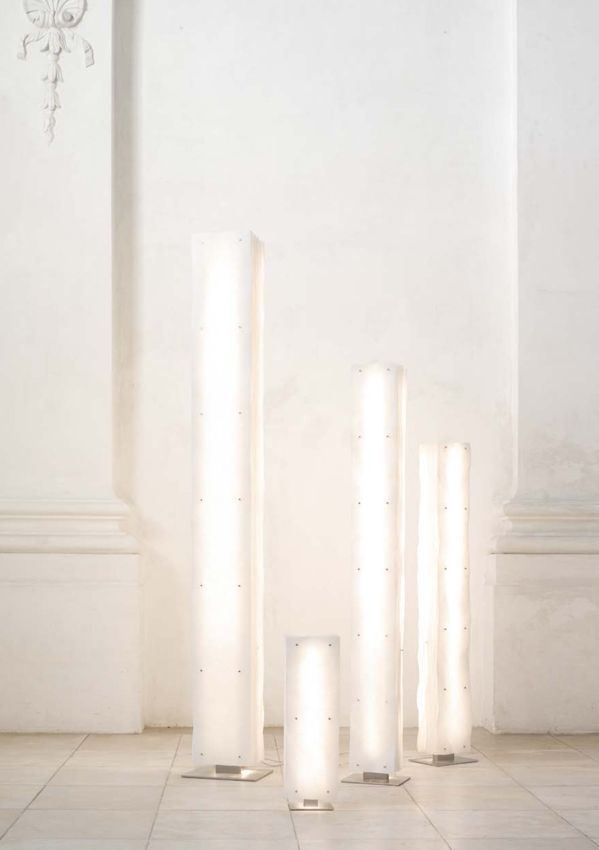 Eine Gruppe weißer Lampen, die nebeneinander auf einem gefliesten Boden stehen.