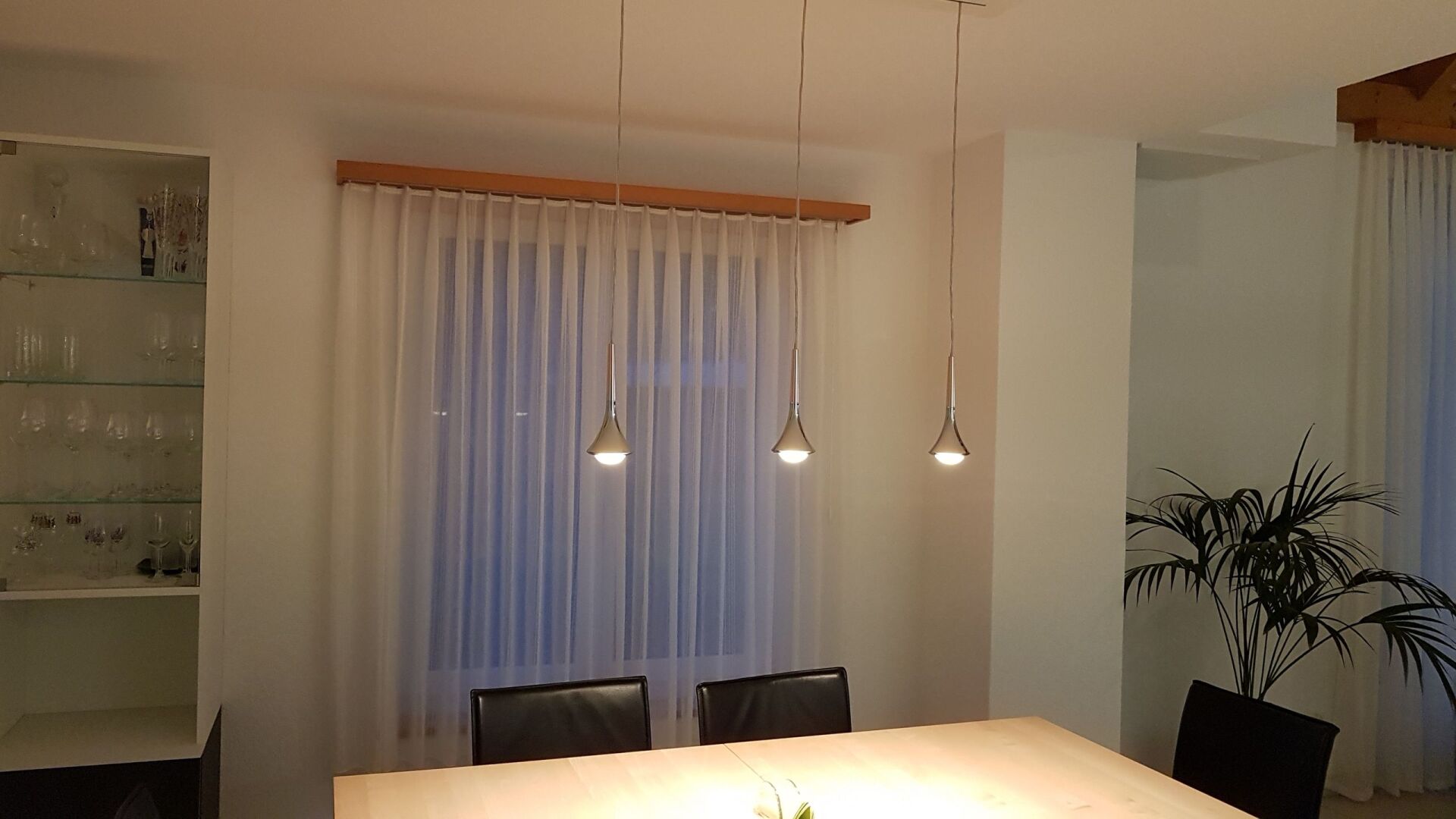 Ein Esszimmer mit Tisch und Stühlen und einem Fenster.
