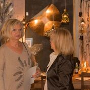 Zwei Frauen stehen nebeneinander in einem Raum und unterhalten sich.