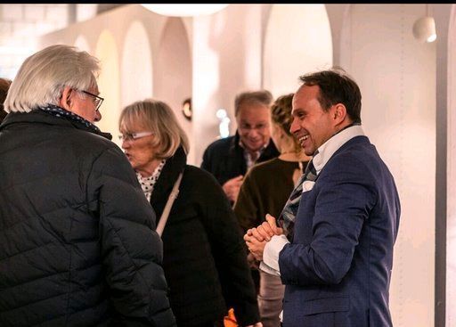 Eine Gruppe von Leuten steht in einem Raum und unterhält sich.