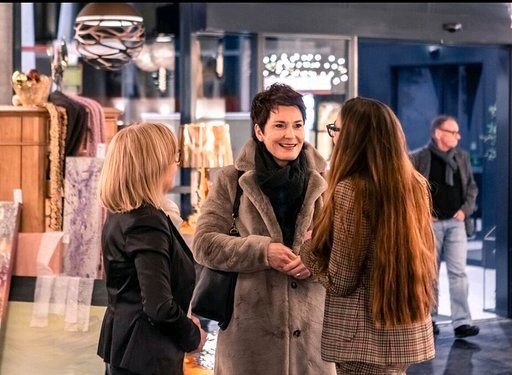 Drei Frauen unterhalten sich in einem Geschäft miteinander.