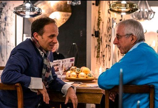 Zwei Männer sitzen an einem Tisch und unterhalten sich