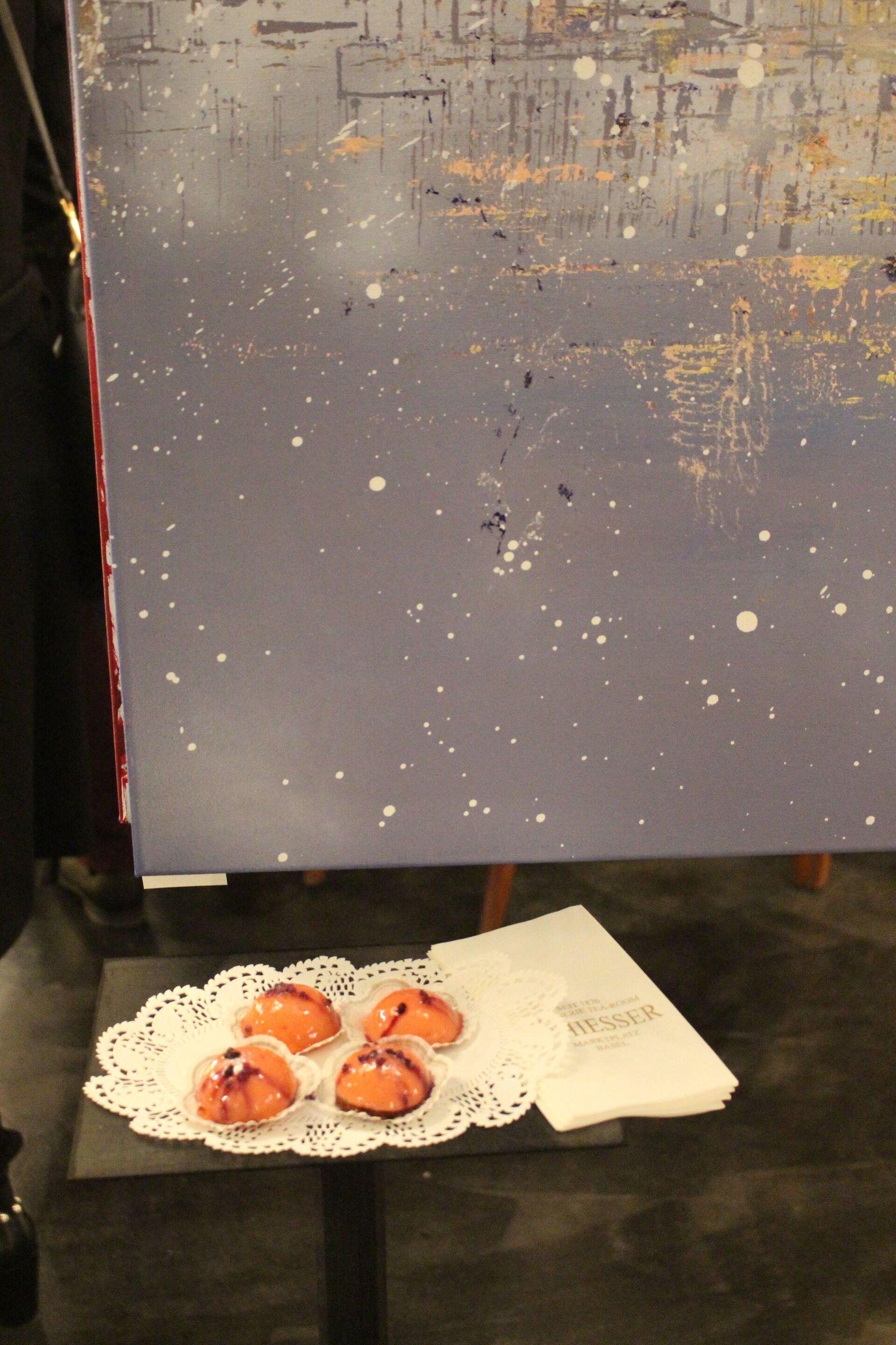 Ein Tisch mit einem Tablett mit Essen vor einem Gemälde