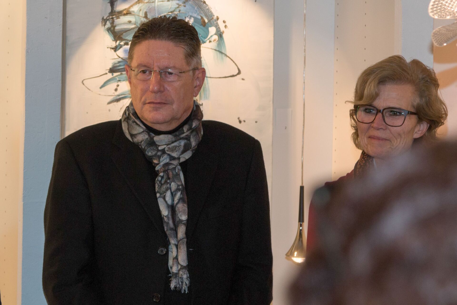 Ein Mann mit Brille und Kopftuch steht neben einer Frau mit Brille