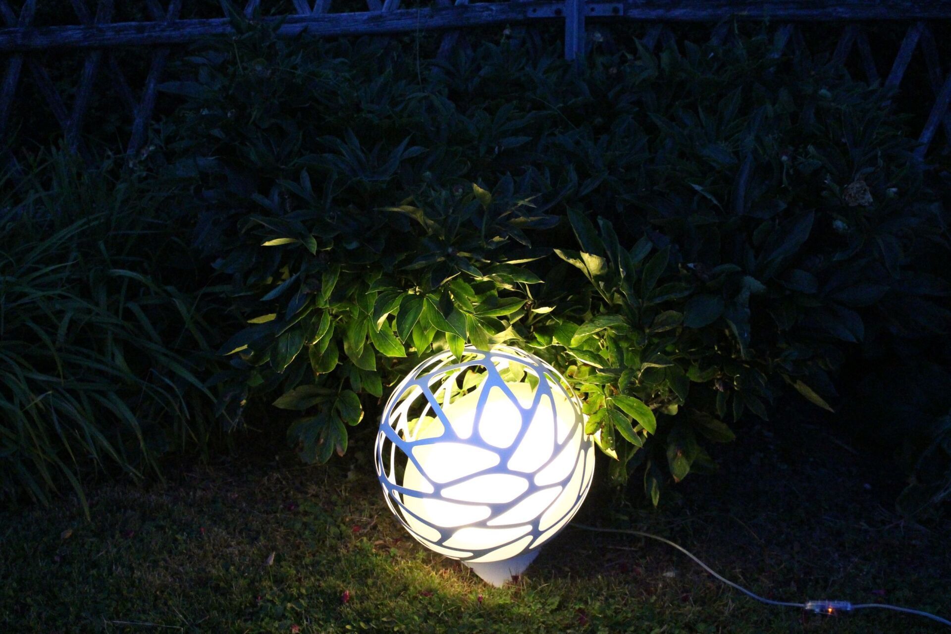 Ein weißer Ball liegt nachts im Gras.