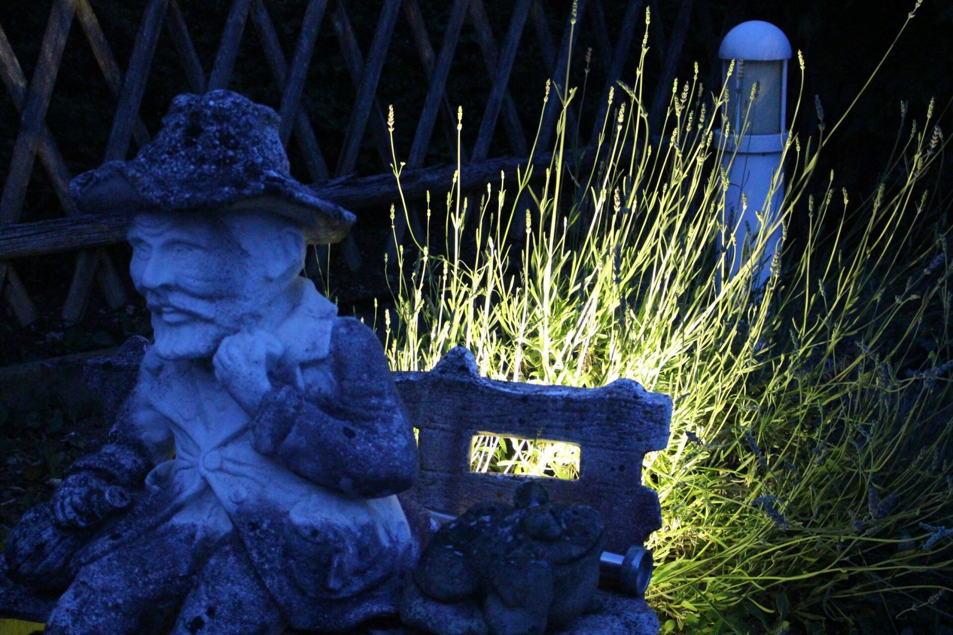 Eine Statue eines Mannes mit Cowboyhut sitzt auf einer Bank