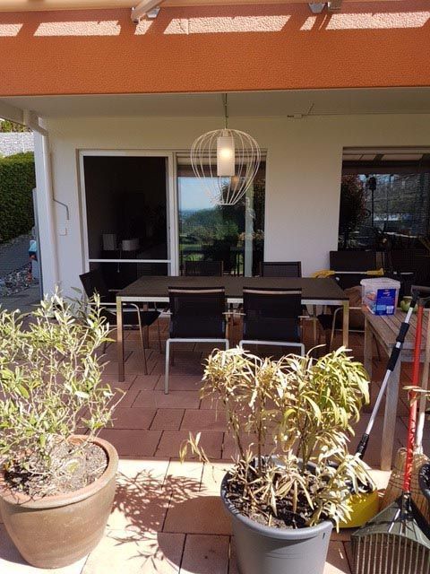 Eine Terrasse mit Tisch und Stühlen und Topfpflanzen