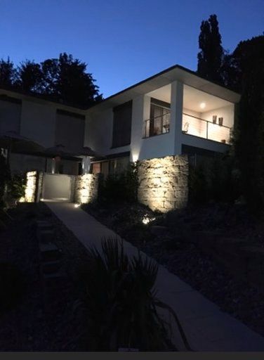 Ein Haus mit Balkon ist nachts beleuchtet