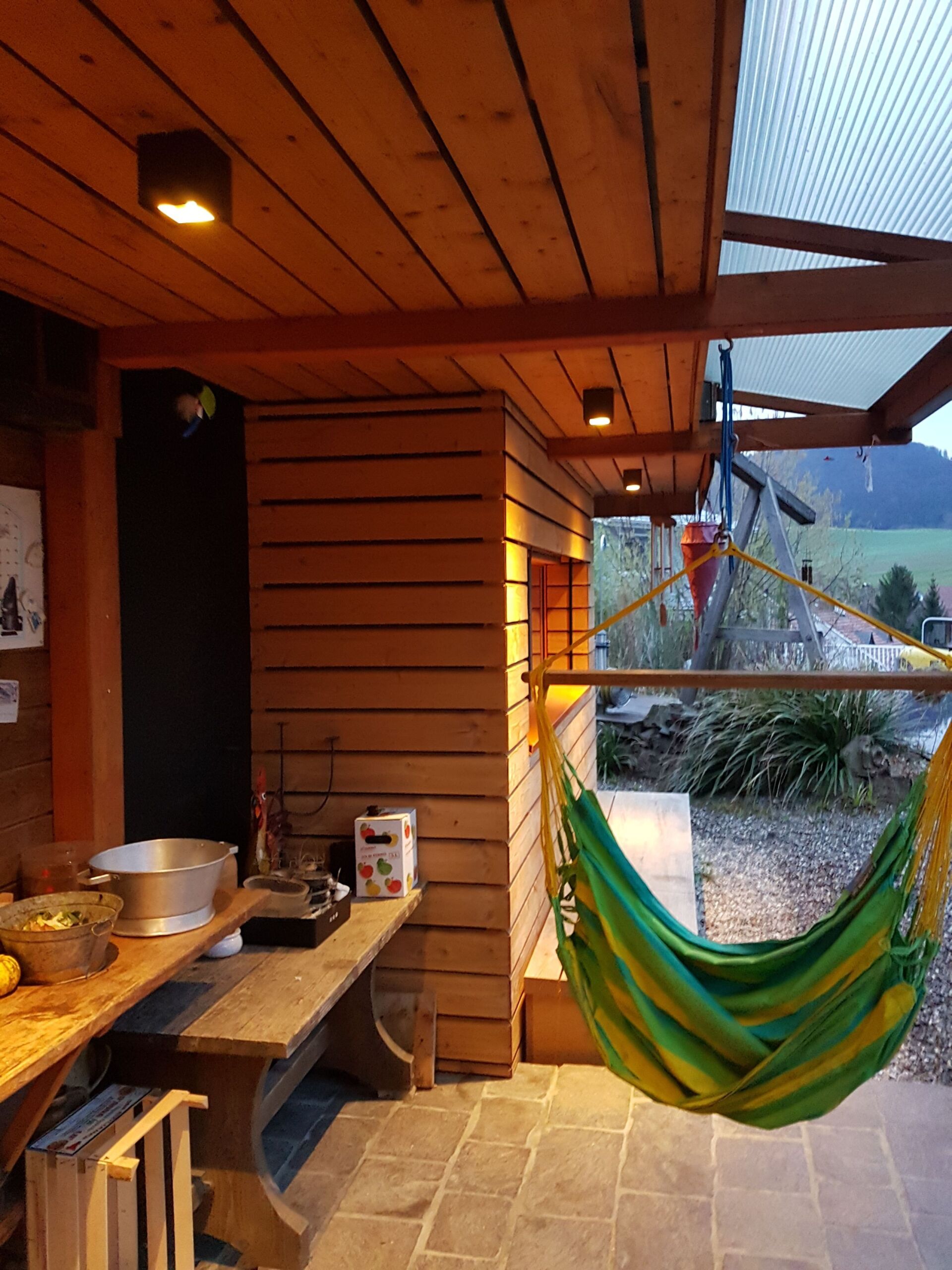 Eine grüne und gelbe Hängematte hängt von der Decke eines Zimmers