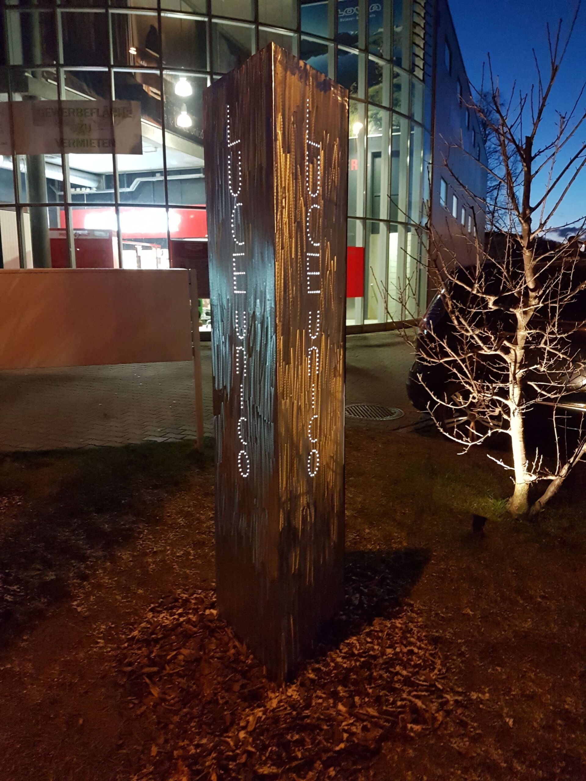 Eine große Holzsäule mit arabischer Schrift darauf