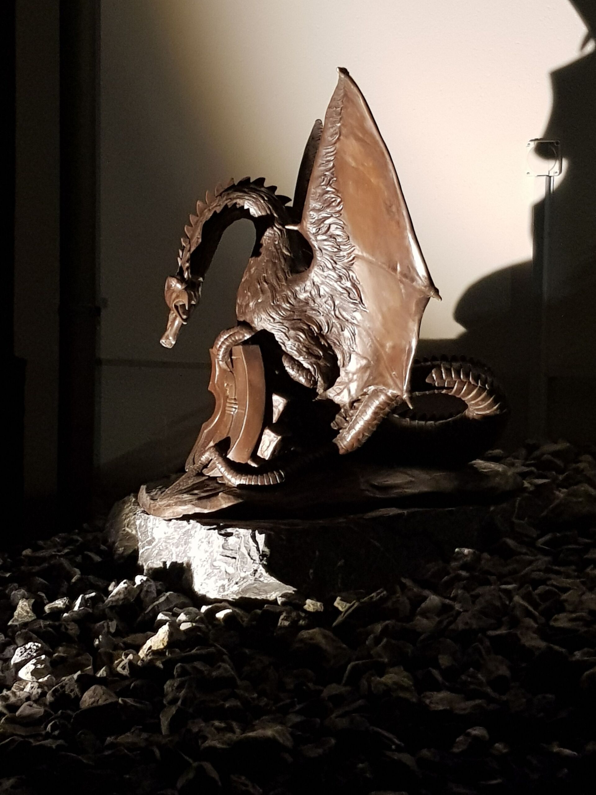 Eine Drachenstatue sitzt auf einem Steinhaufen