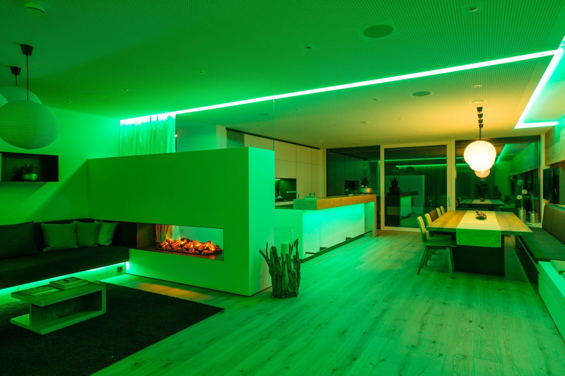 Ein Wohnzimmer und ein Esszimmer mit grünen Lichtern an der Decke.
