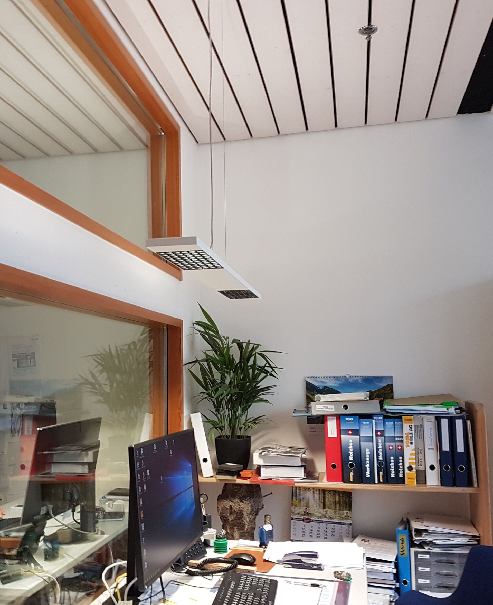 Ein Computermonitor steht auf einem Schreibtisch in einem Büro