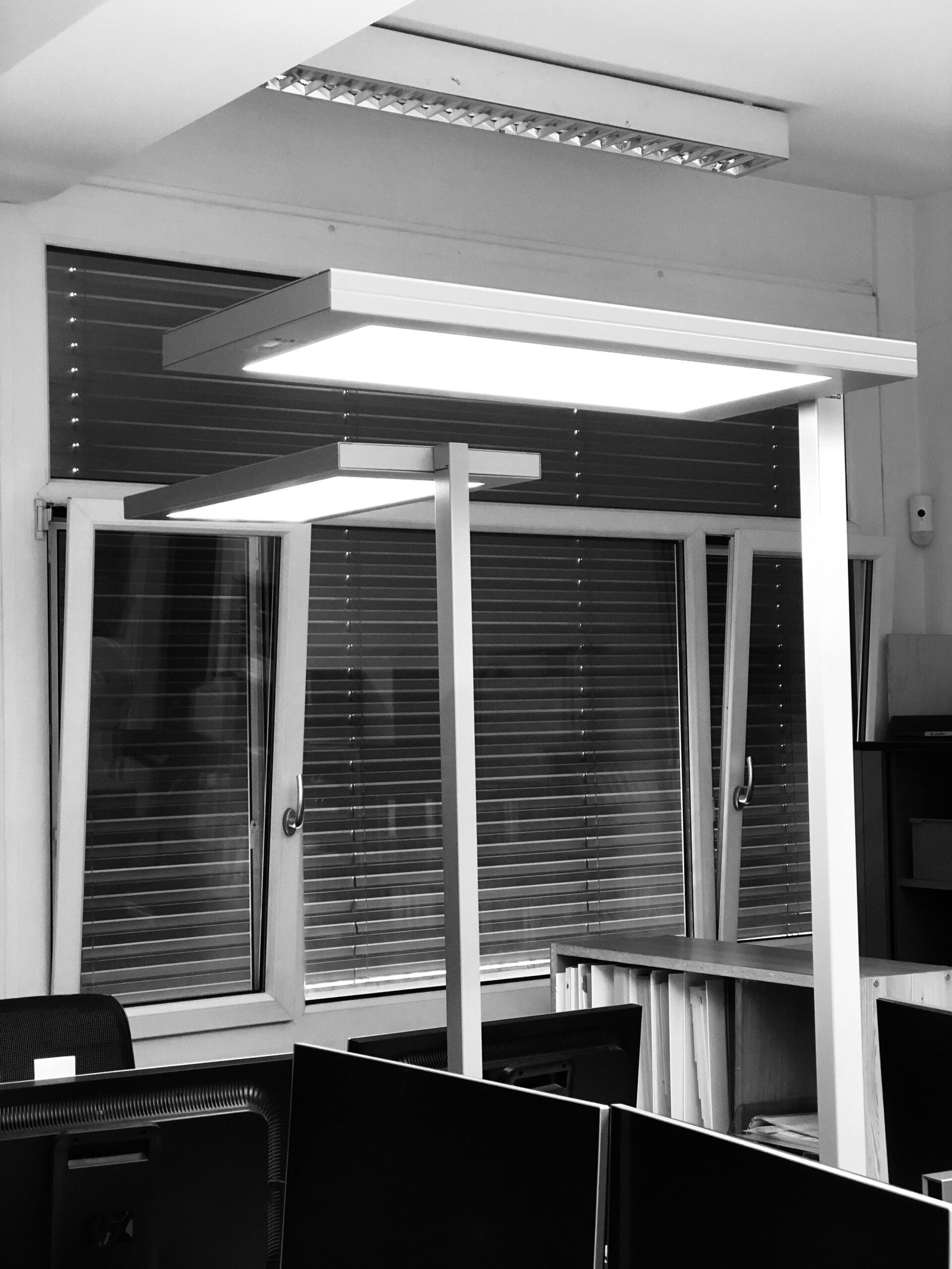 Ein Schwarzweißfoto eines Büros mit Jalousien an den Fenstern