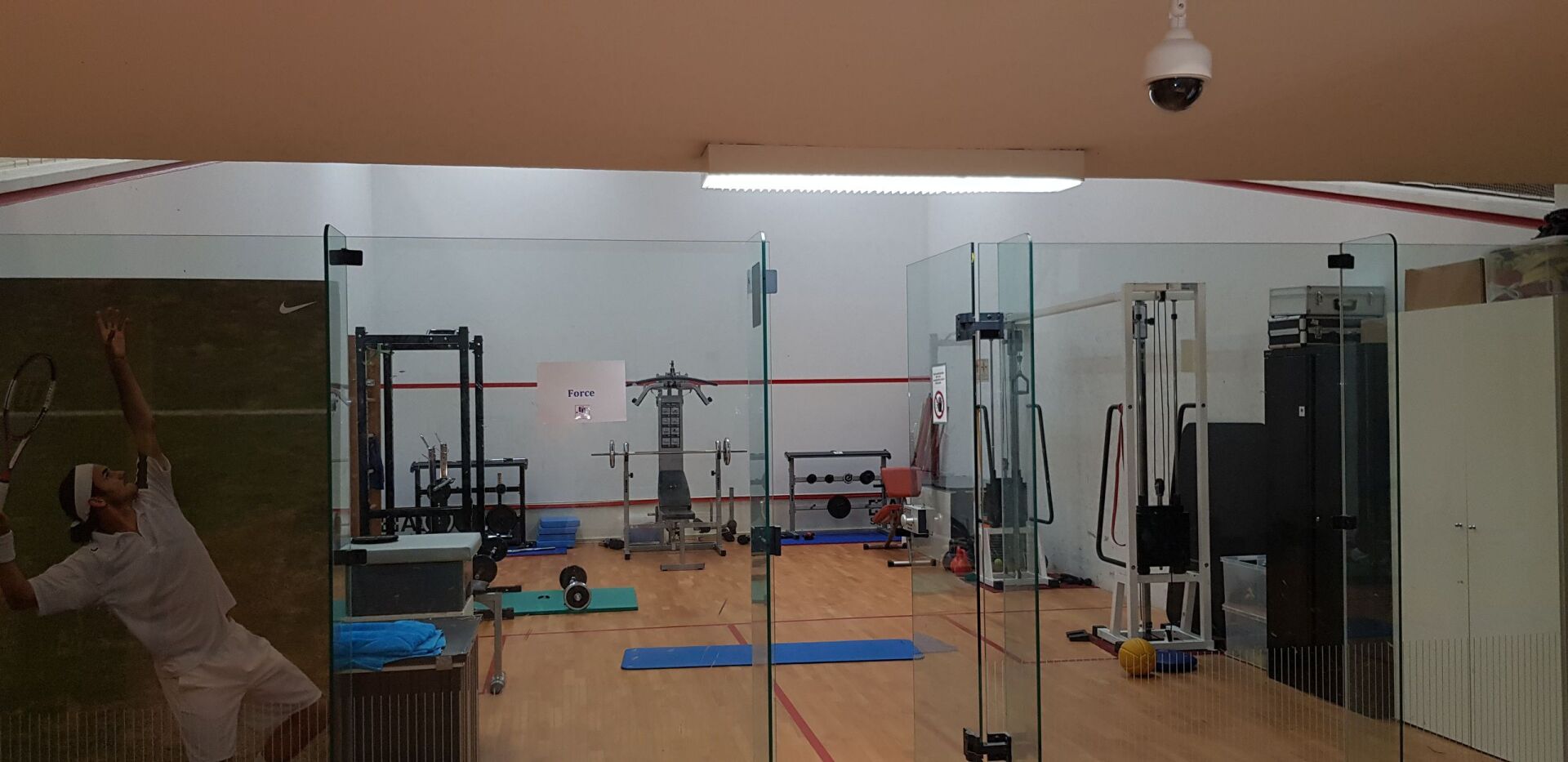 Ein Fitnessstudio mit vielen Geräten und einer Kamera an der Decke.
