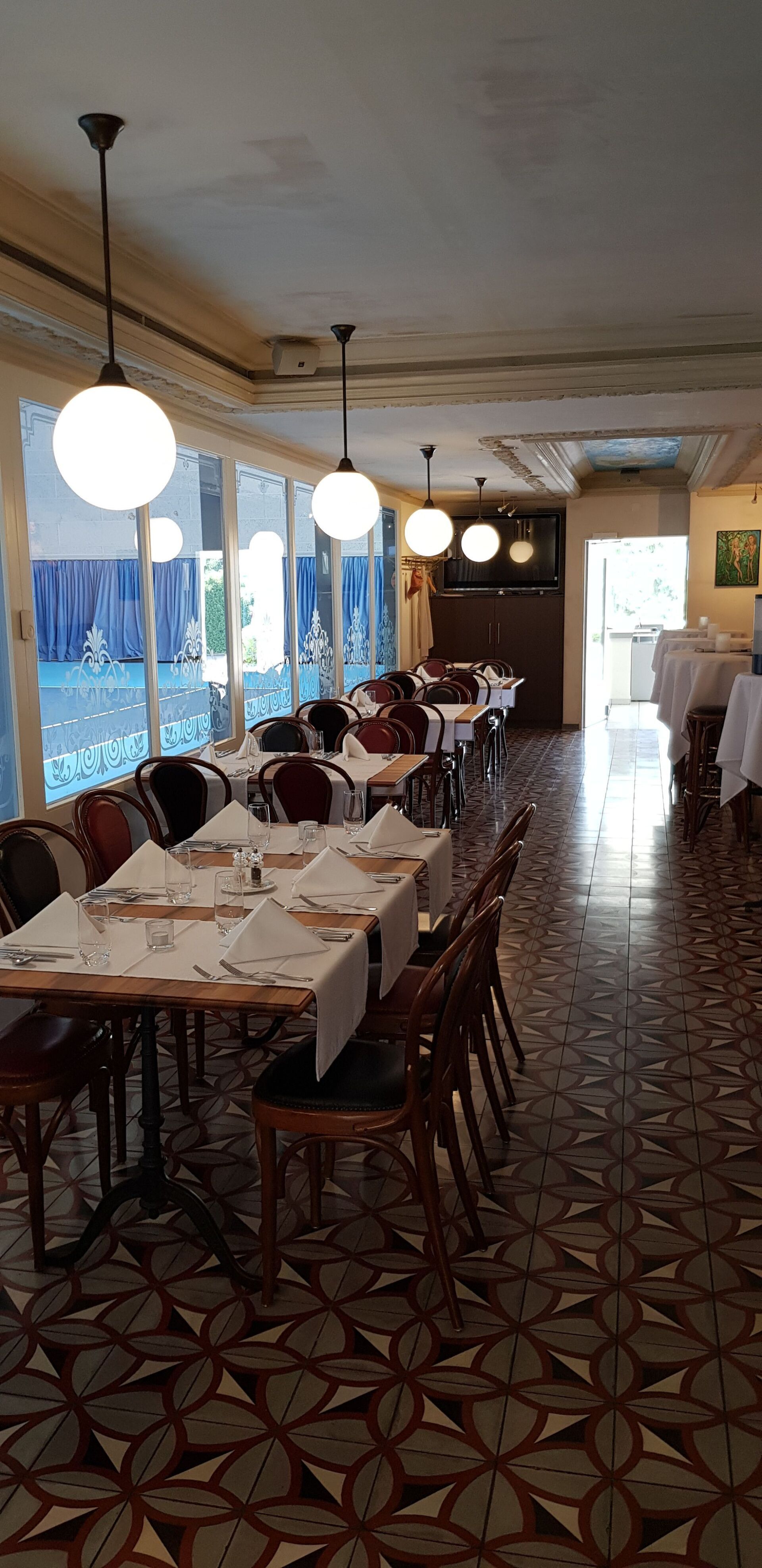 Ein Restaurant mit Tischen und Stühlen und gefliestem Boden.