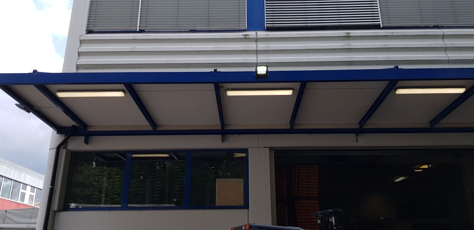 Die Vorderseite eines Gebäudes mit einer blauen Markise darüber.