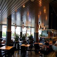 Ein Restaurant mit Tischen und Stühlen und einer sehr hohen Decke.