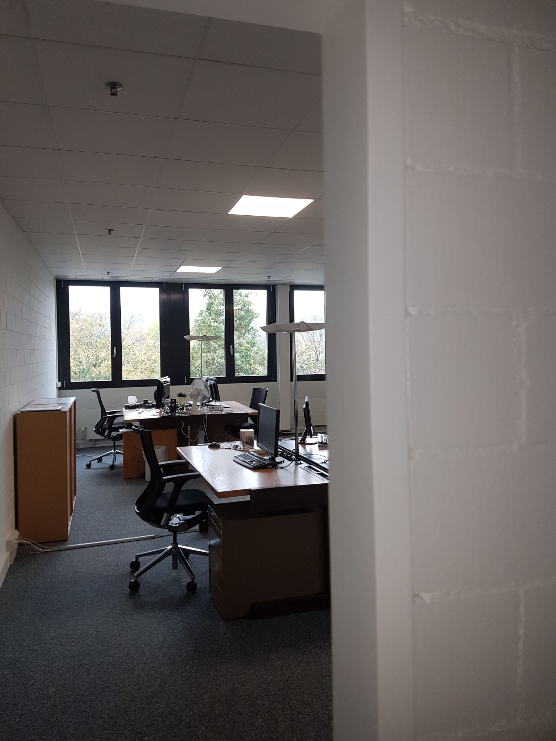 Ein Büro mit vielen Schreibtischen und Stühlen