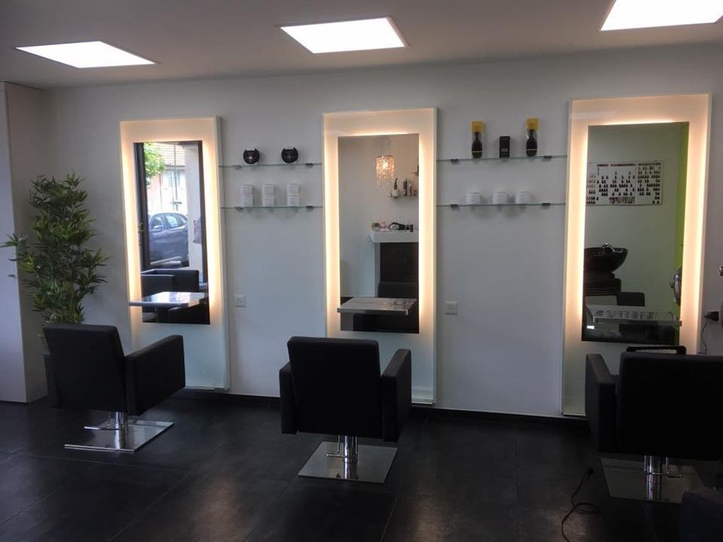 Ein Friseursalon mit drei Stühlen und drei Spiegeln