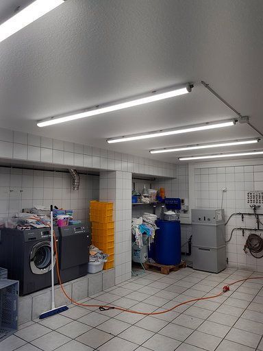 Eine Waschküche mit Waschmaschine, Trockner und Besen.