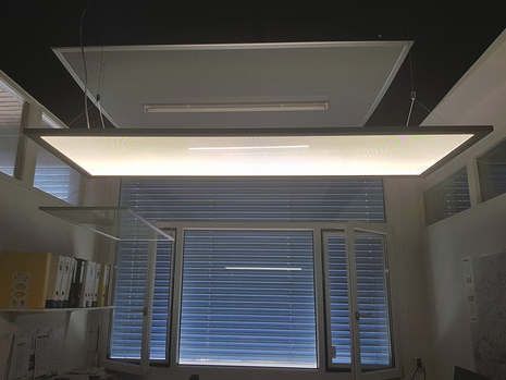 In einem Raum mit Fenster hängt eine Deckenleuchte von der Decke.