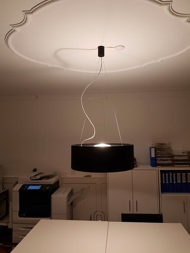In einem Raum mit einem Drucker hängt eine Lampe von der Decke.