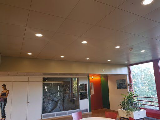 Eine Frau steht in einem Raum mit einem Tisch und Stühlen.