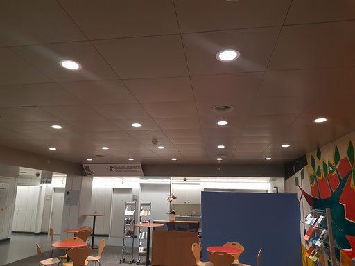 Ein Raum mit Tischen und Stühlen und einem Gemälde an der Wand.