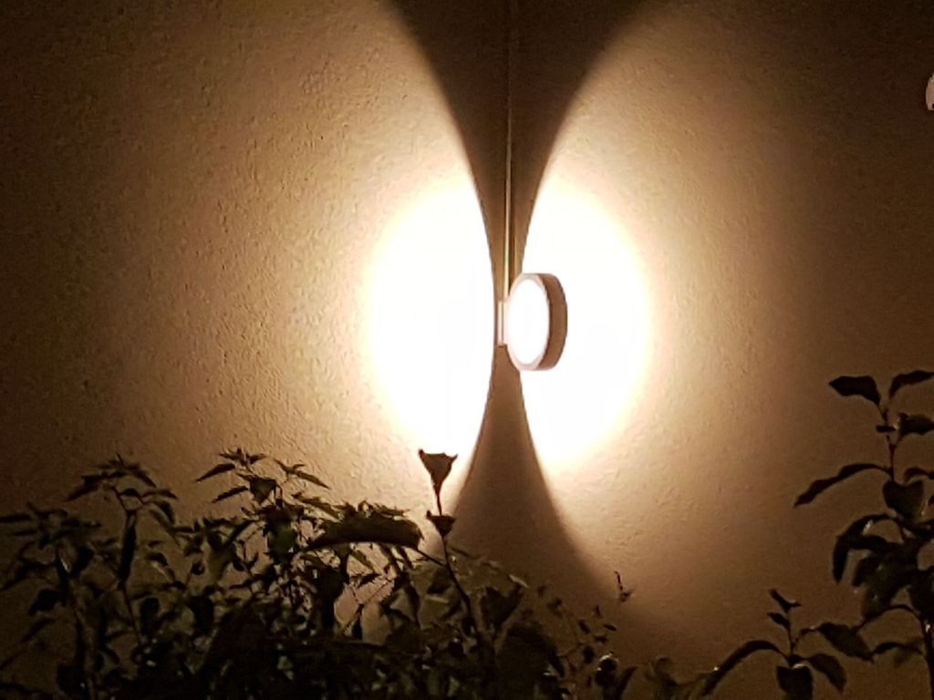 Nachts scheint ein Licht auf eine Wand.