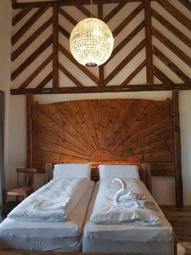 Ein Schlafzimmer mit zwei Betten und einem hölzernen Kopfteil