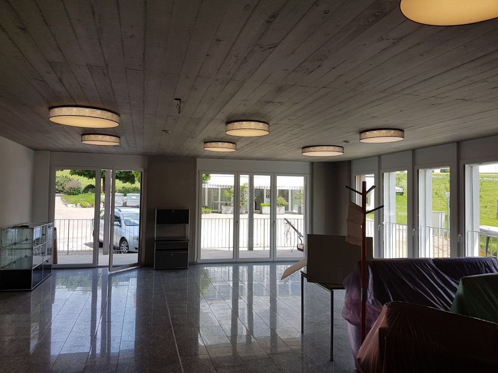 Ein großer Raum mit vielen Fenstern und einer Couch