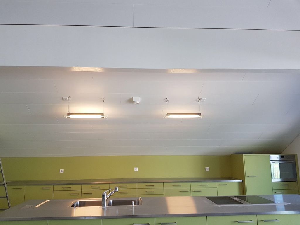 Eine Küche mit grünen Schränken und Edelstahl-Arbeitsplatten