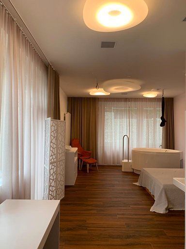 Ein Schlafzimmer mit zwei Betten, einer Badewanne und einem großen Fenster.