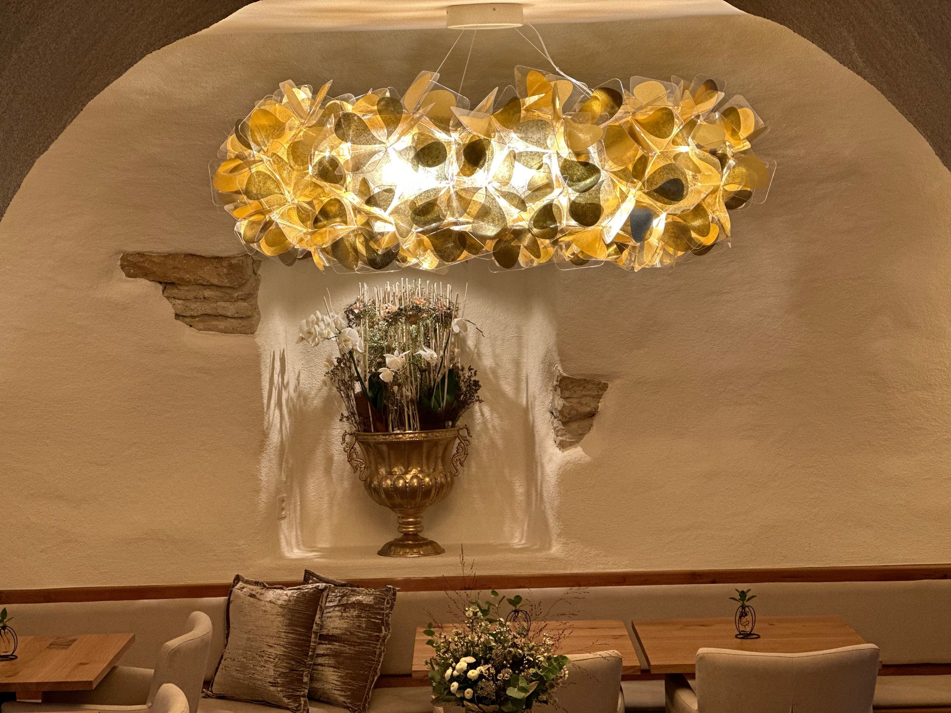 Ein Raum mit Tischen und Stühlen und einer Blumenvase an der Wand