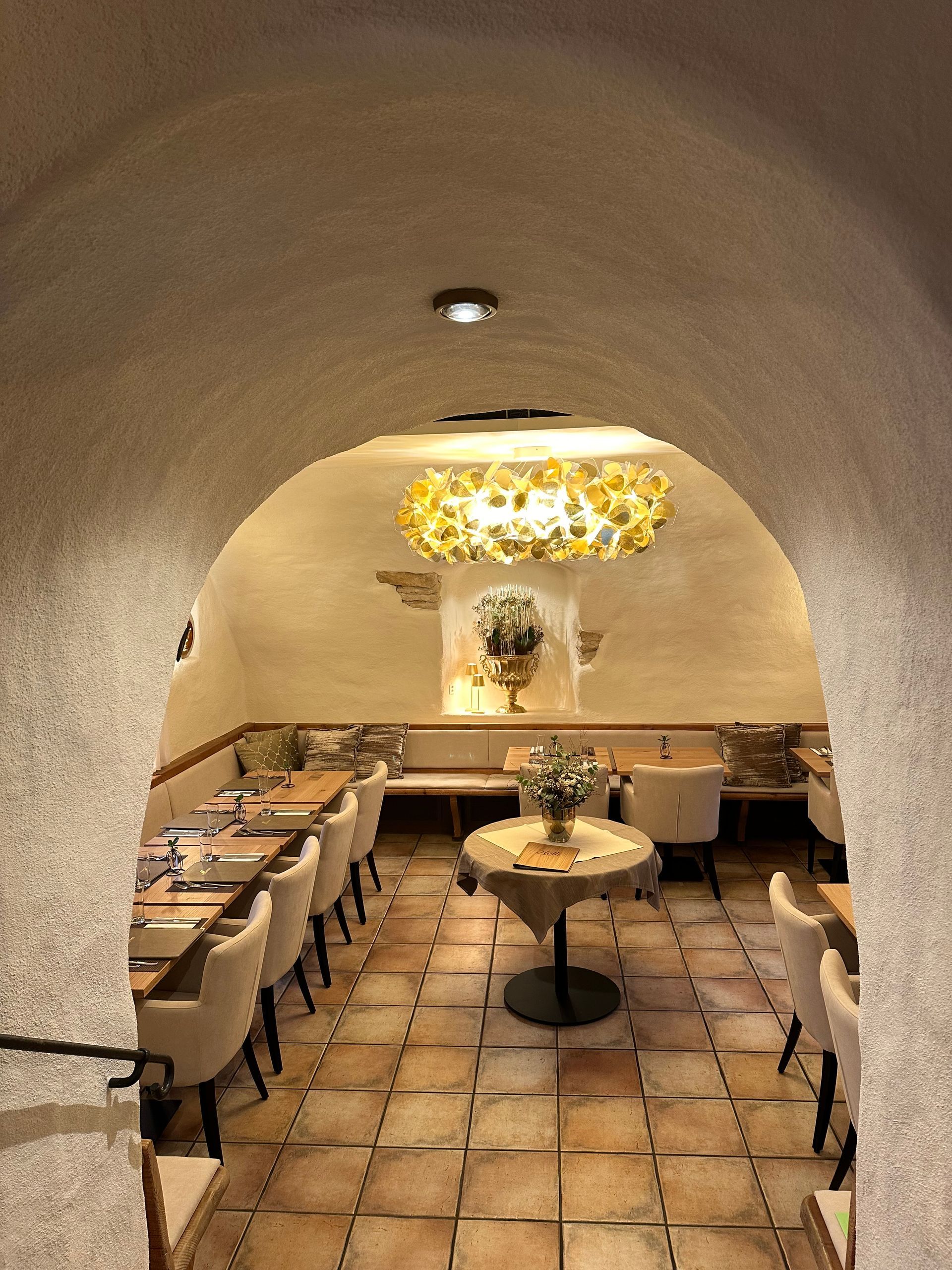 Ein Restaurant mit Tischen und Stühlen und einem Kronleuchter, der von der Decke hängt.