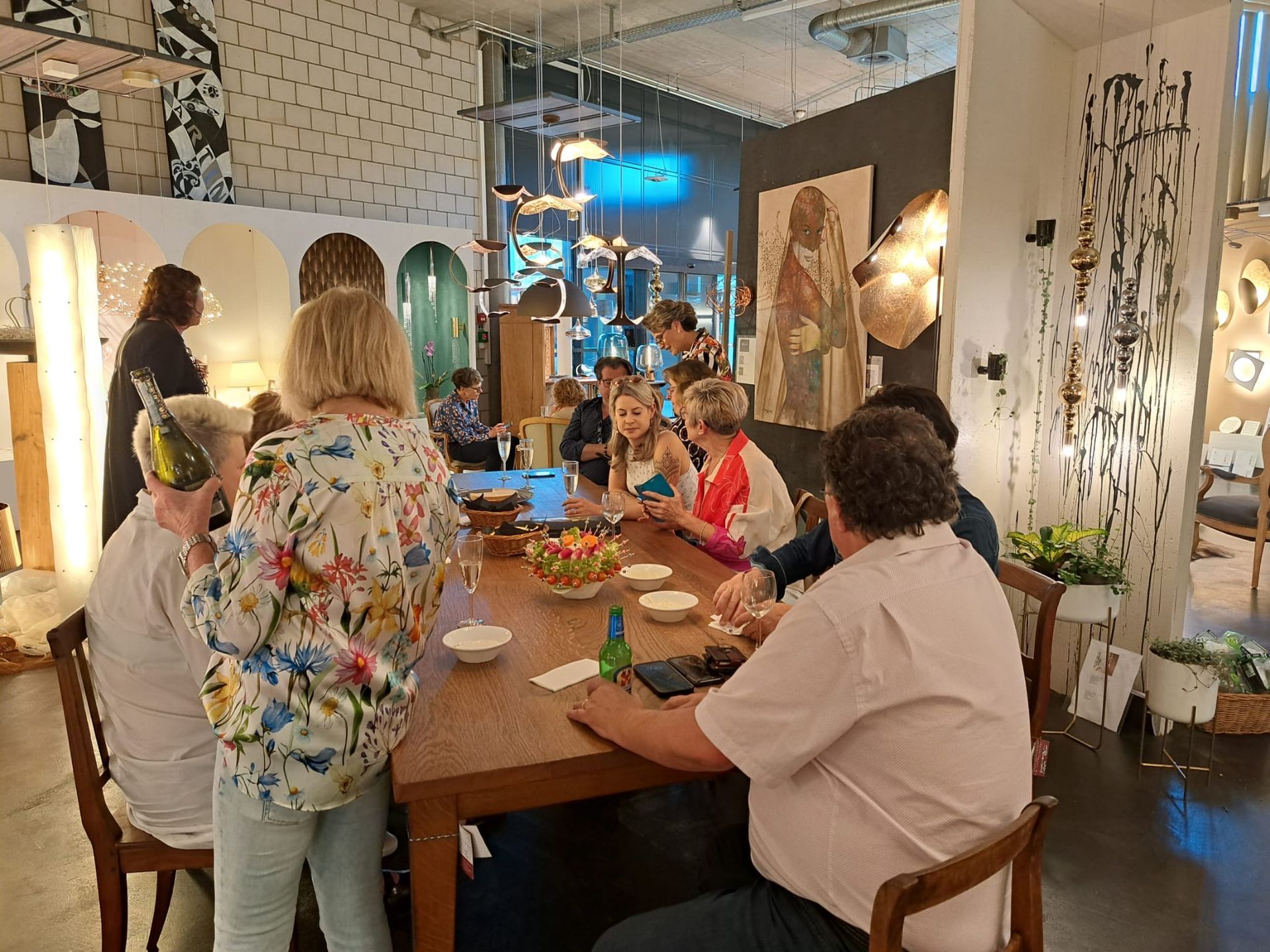 Eine Gruppe von Leuten sitzt in einem Raum um einen Tisch herum.