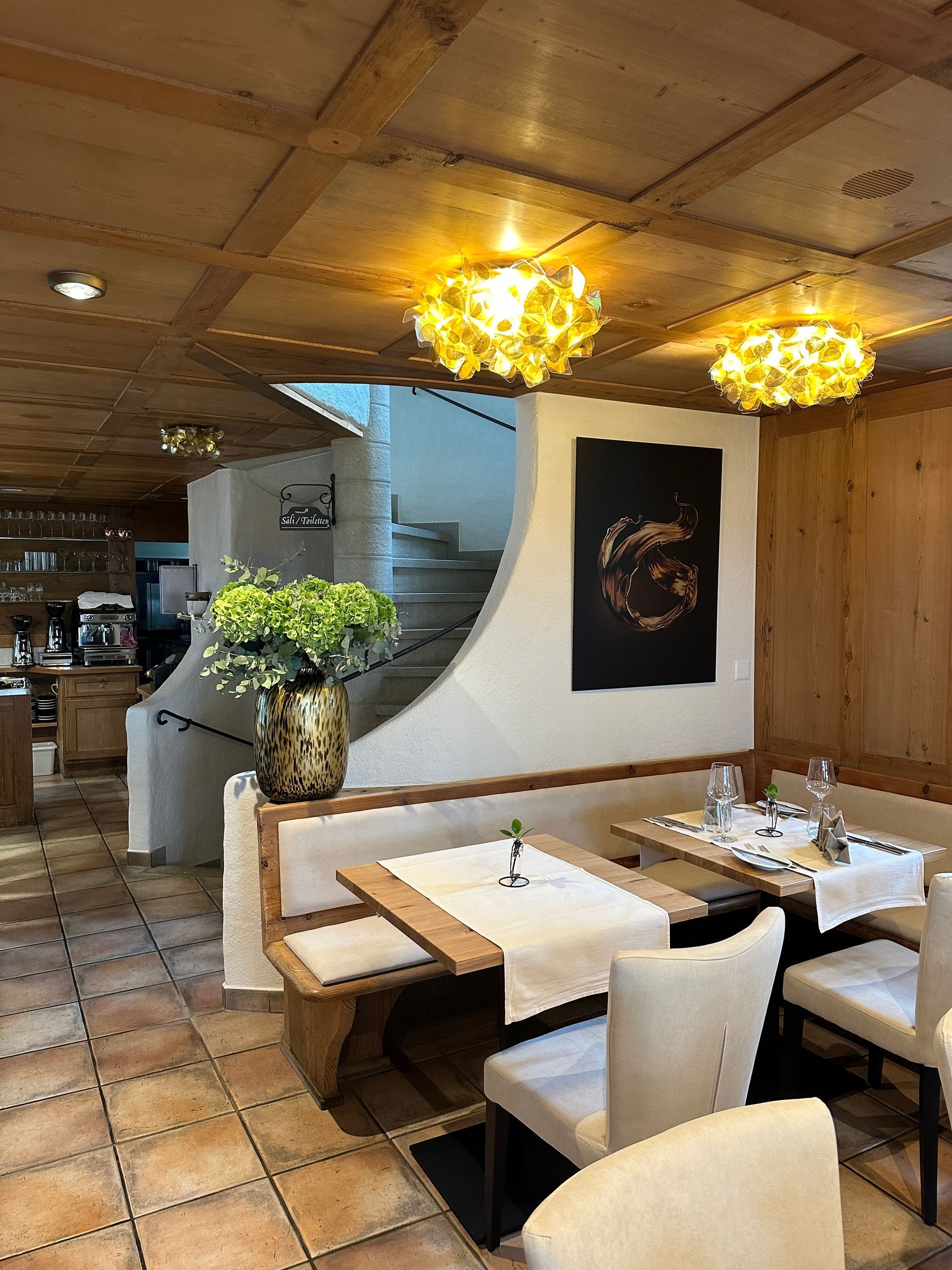 Ein Restaurant mit Tischen und Stühlen und einer Vase mit Blumen auf dem Tisch.