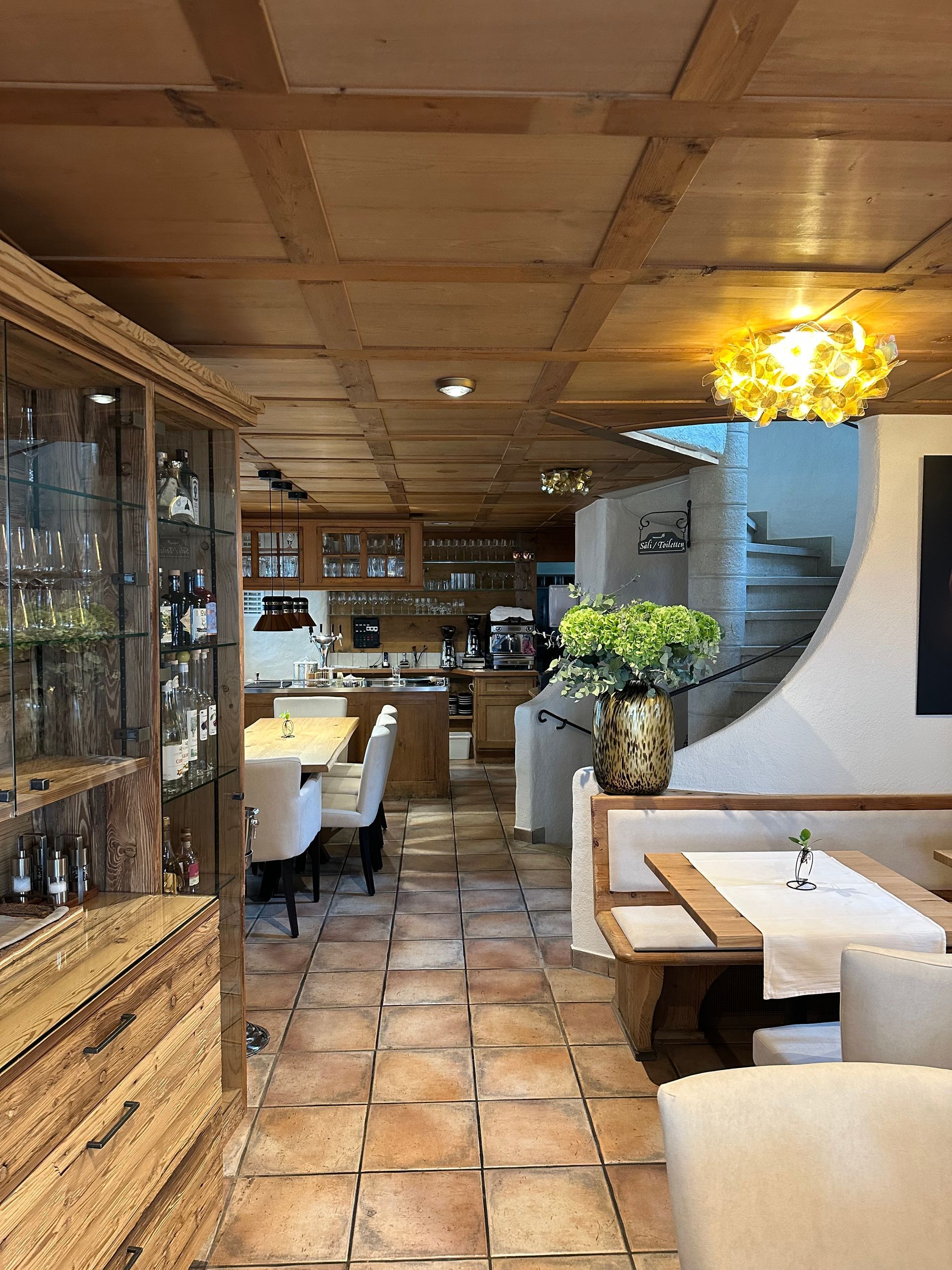 Ein Restaurant mit Holzdecke und Tischen und Stühlen.