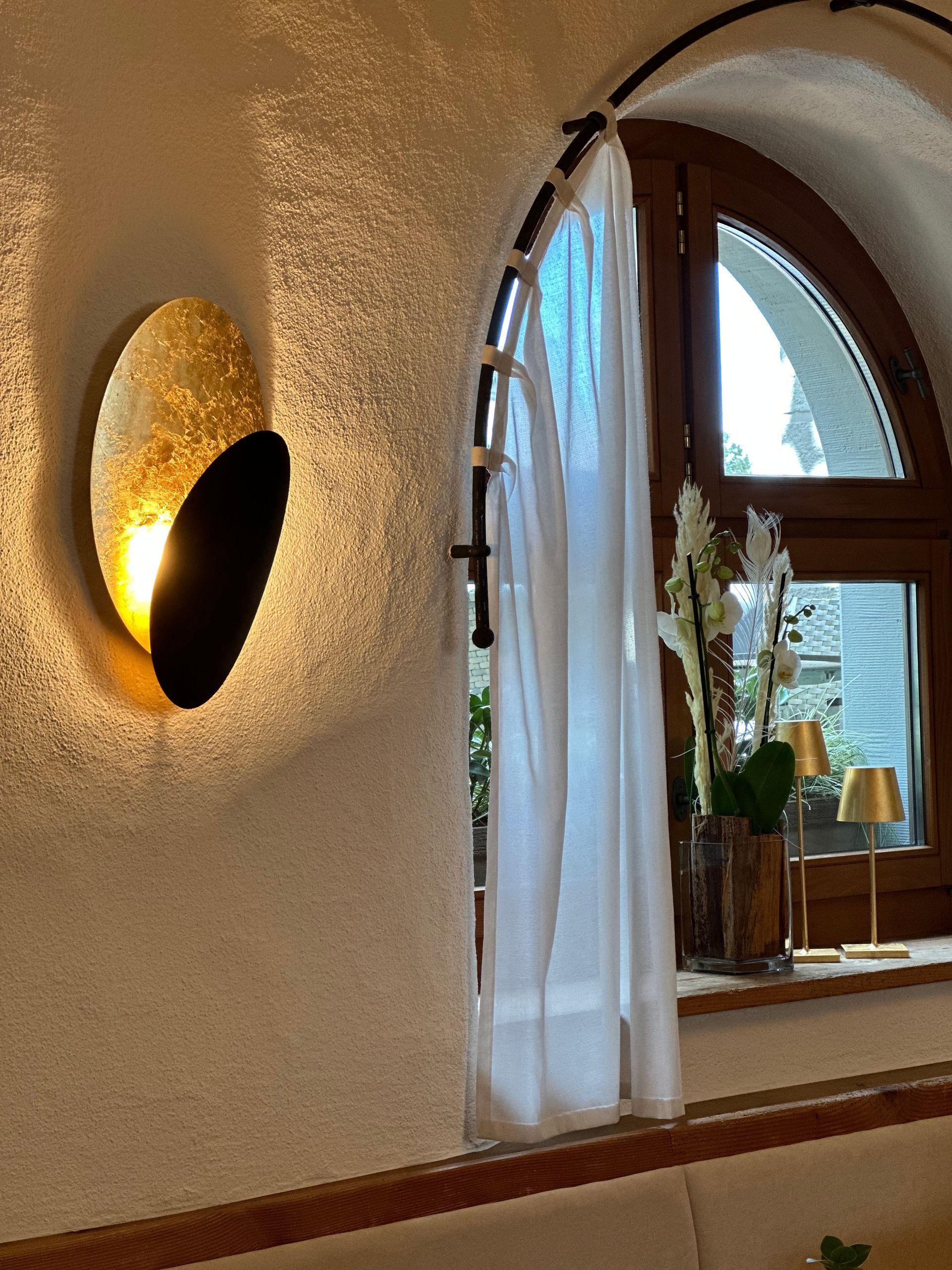 Ein Raum mit einem Fenster und einer Lampe an der Wand