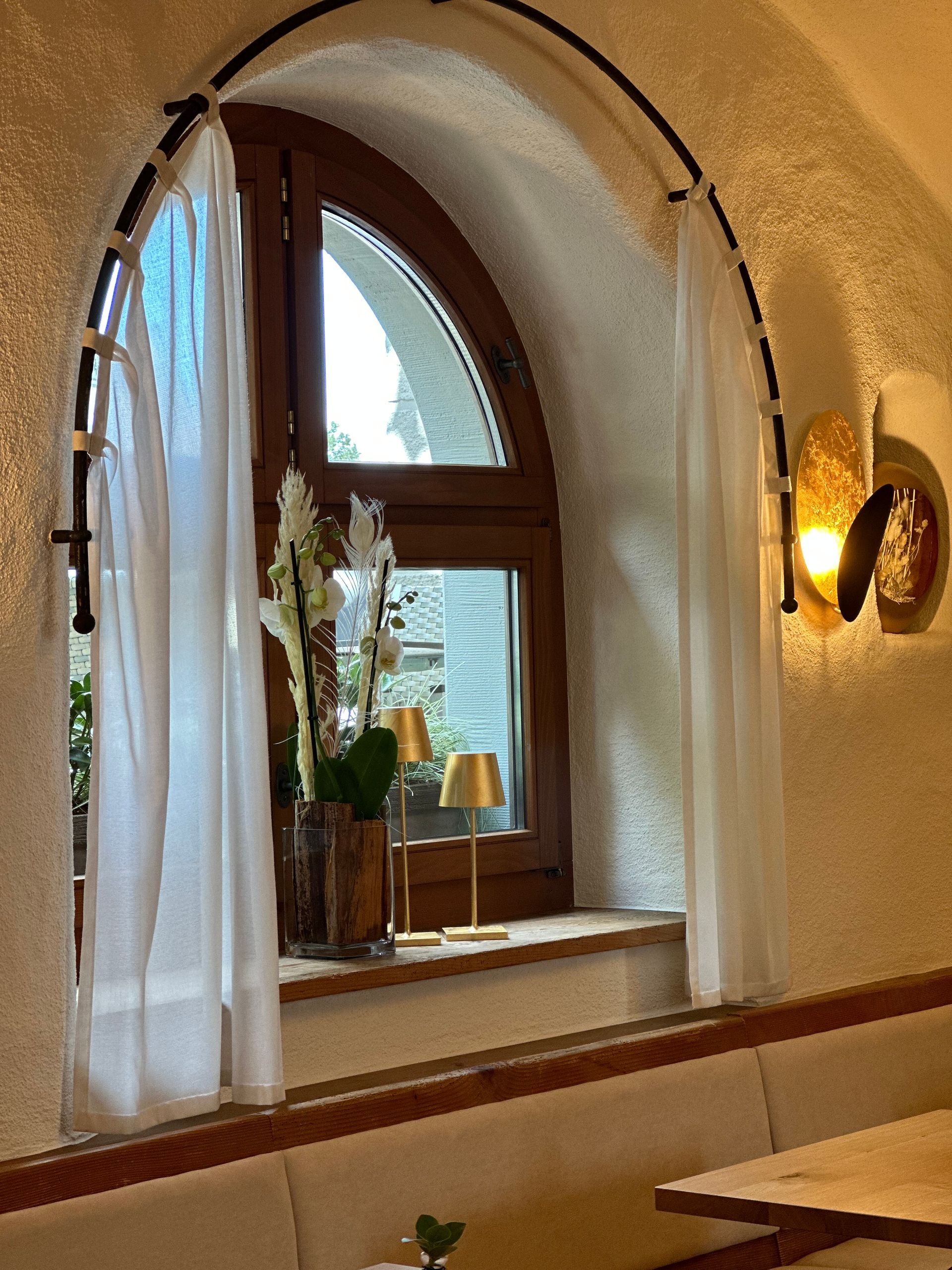 Ein Fenster mit weißen Vorhängen und einer Lampe daran