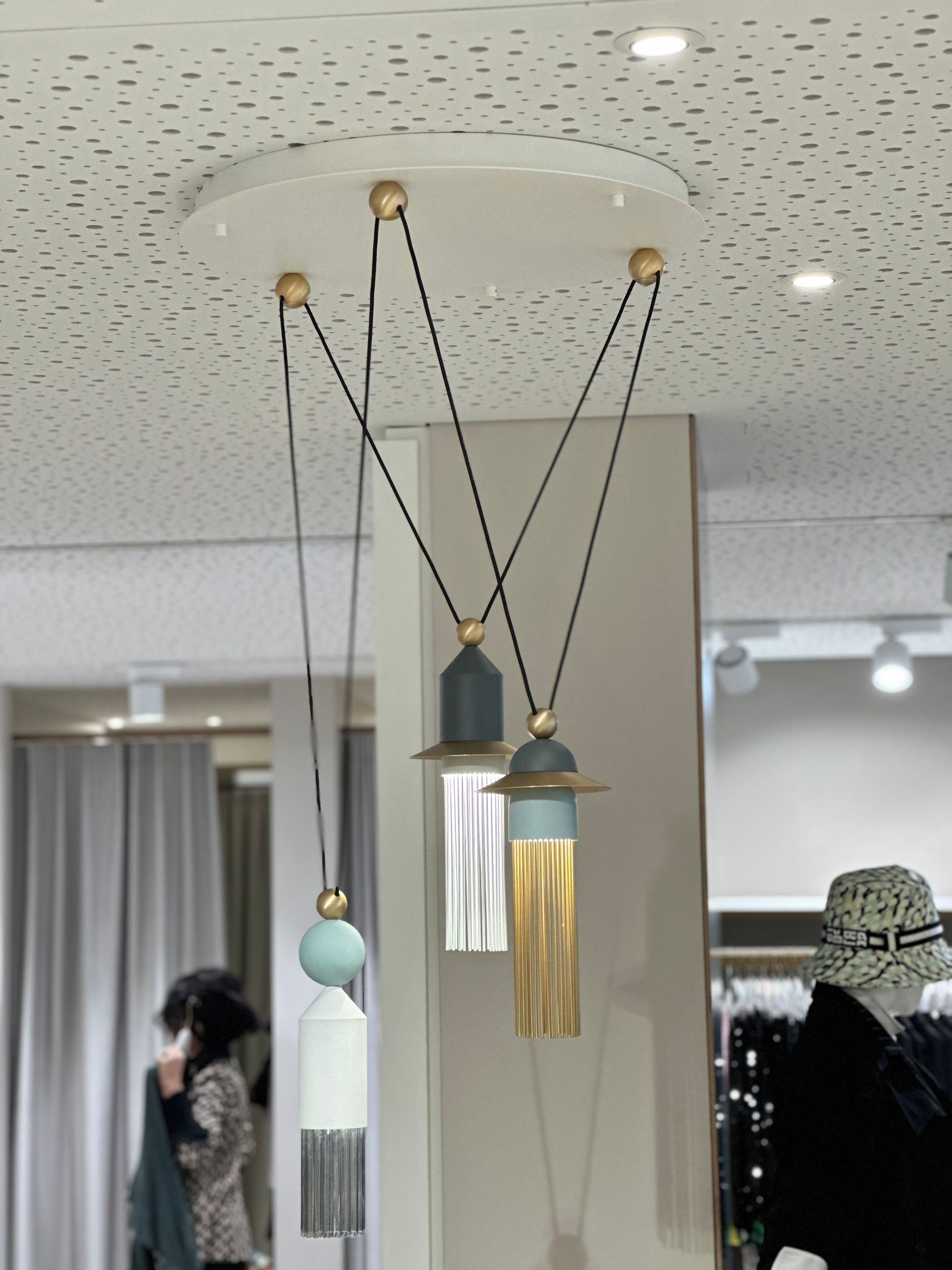 Eine Frau mit Hut steht vor einer Deckenleuchte