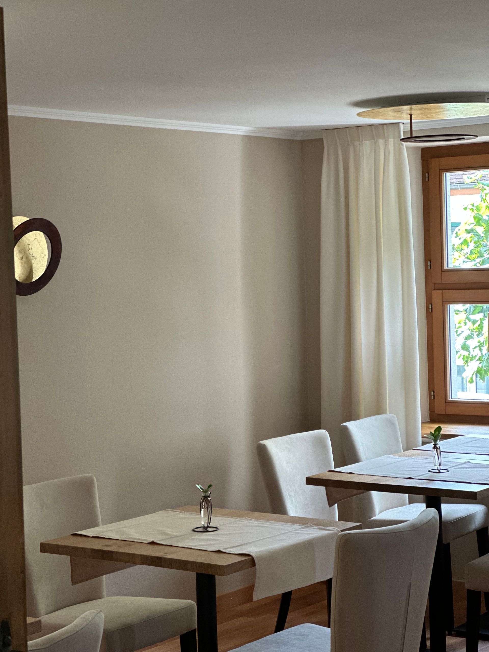 Ein Esszimmer mit Tischen und Stühlen und einem Fenster