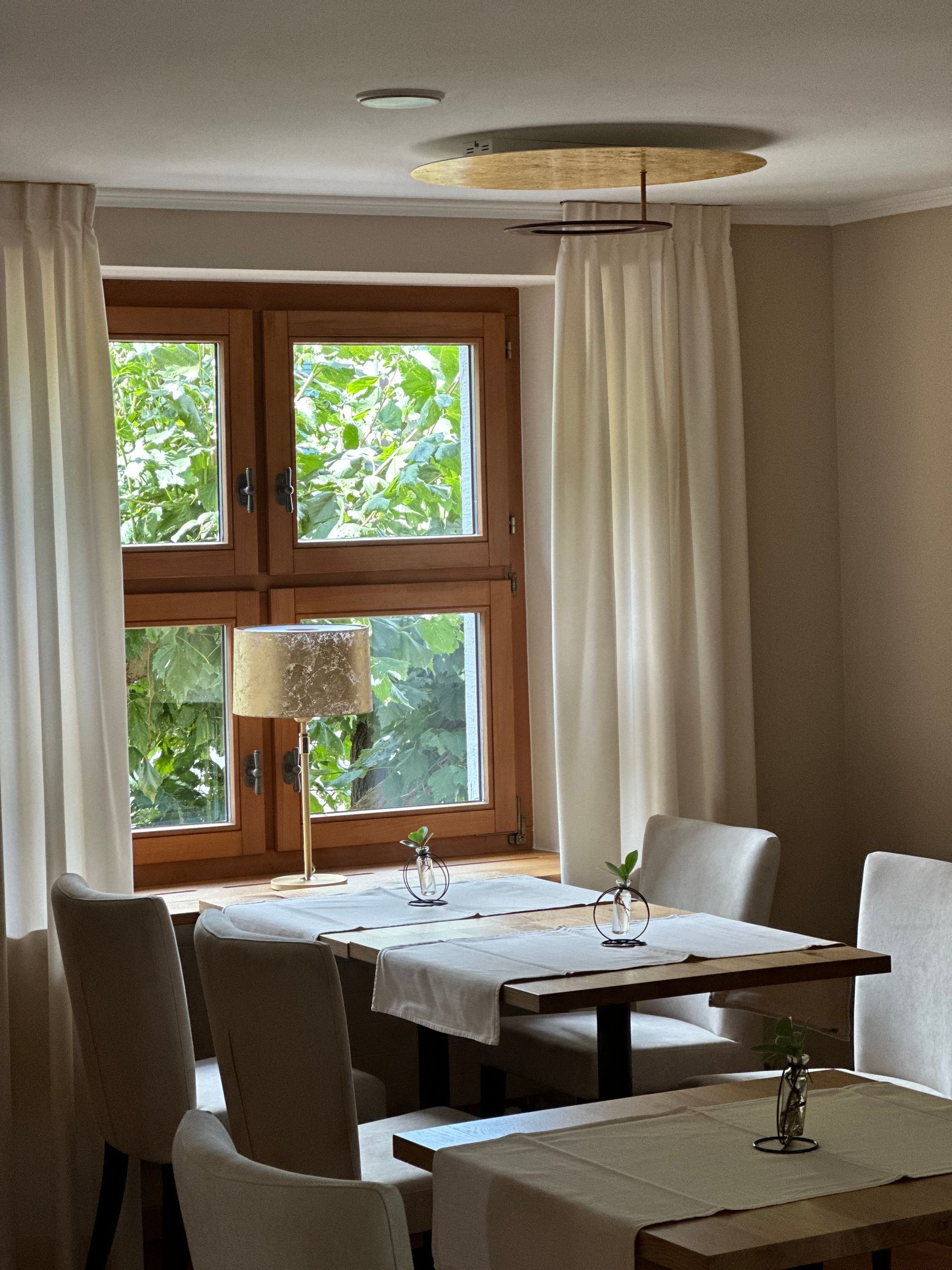 Ein Esszimmer mit einem Tisch und Stühlen vor einem Fenster