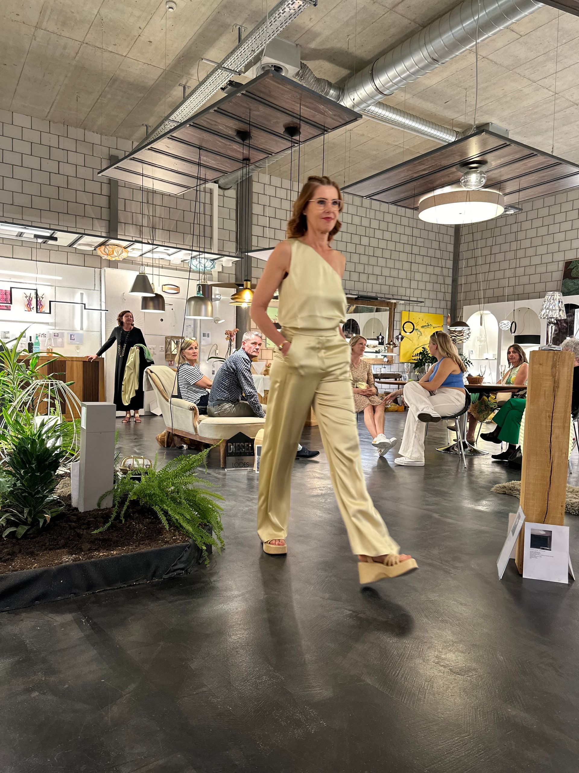 Eine Frau in einem gelben Kleid geht in einen Raum.