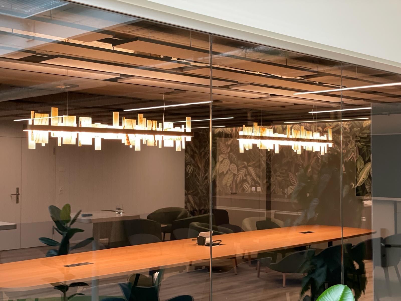 Ein Konferenzraum mit einem langen Tisch und Stühlen hinter einer Glaswand.