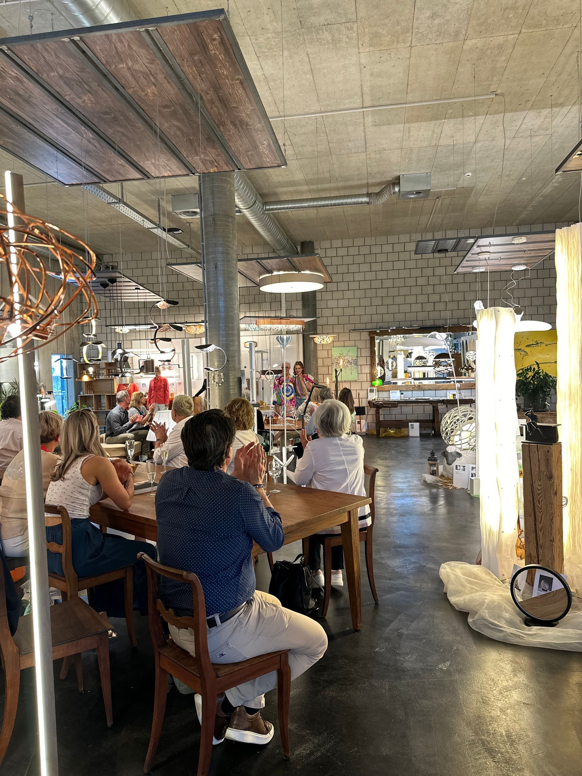 Eine Gruppe von Leuten sitzt an Tischen in einem Restaurant.