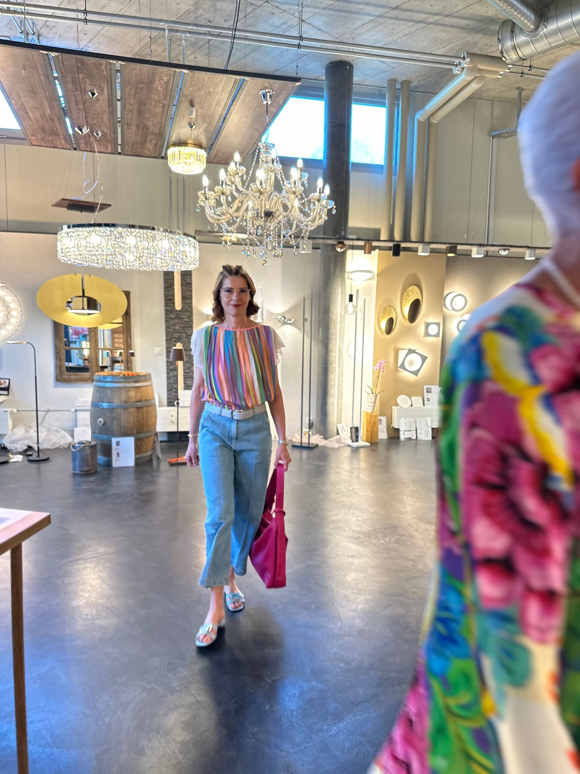 Eine Frau geht in einen Raum mit einem Kronleuchter.