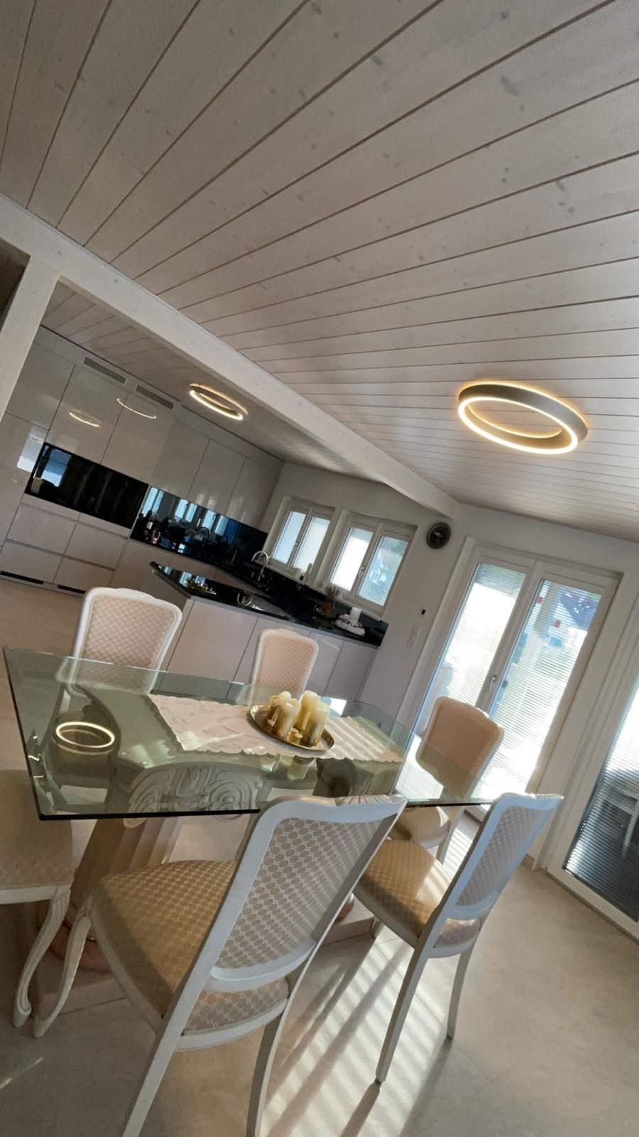 Ein Esszimmer mit einem Glastisch und Stühlen in einem Haus.